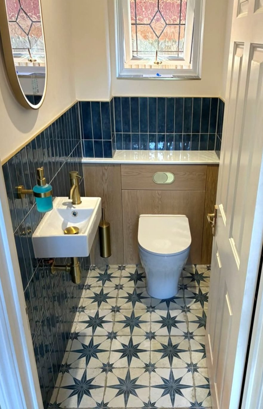 Downstairs cloakroom with a wall-hung basin, concealed cistern WC and star floor tiles