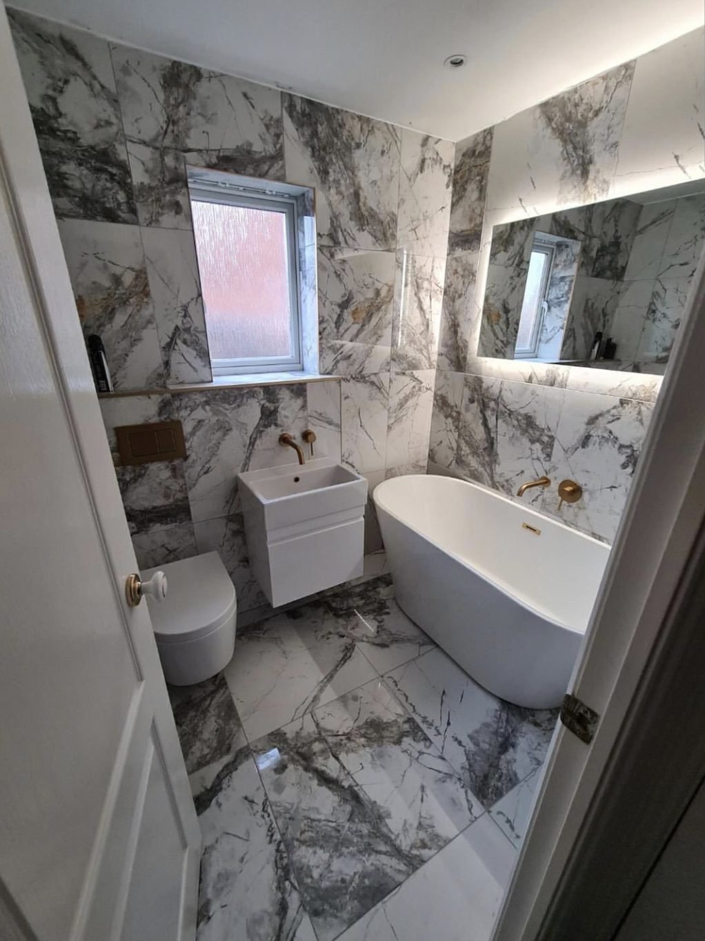 Bathroom installation Doncaster — marble tiled bathroom with freestanding bath